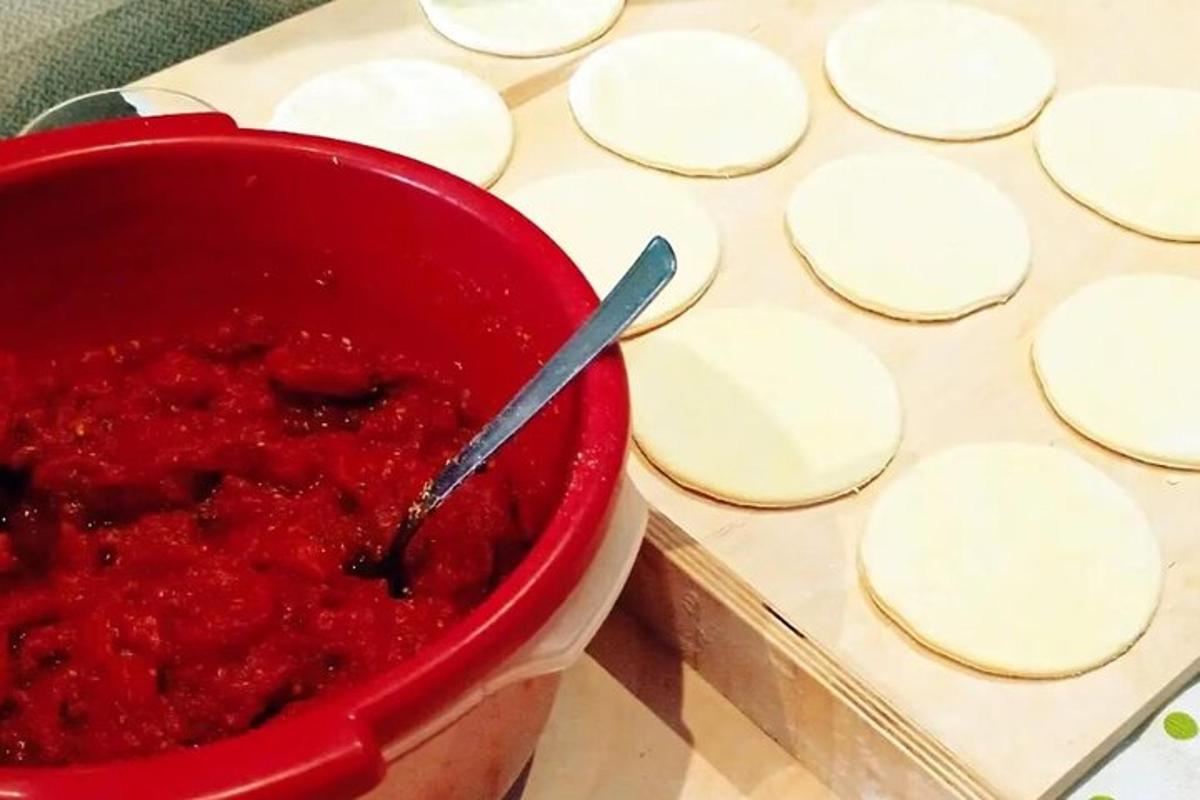 rauð skál af rauðri sósu við hliðina á fullt af mat