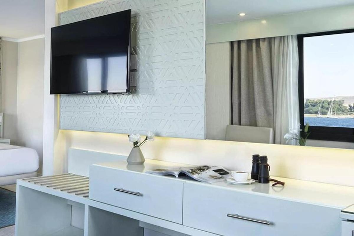 Una cocina blanca con un gran espejo en la pared.