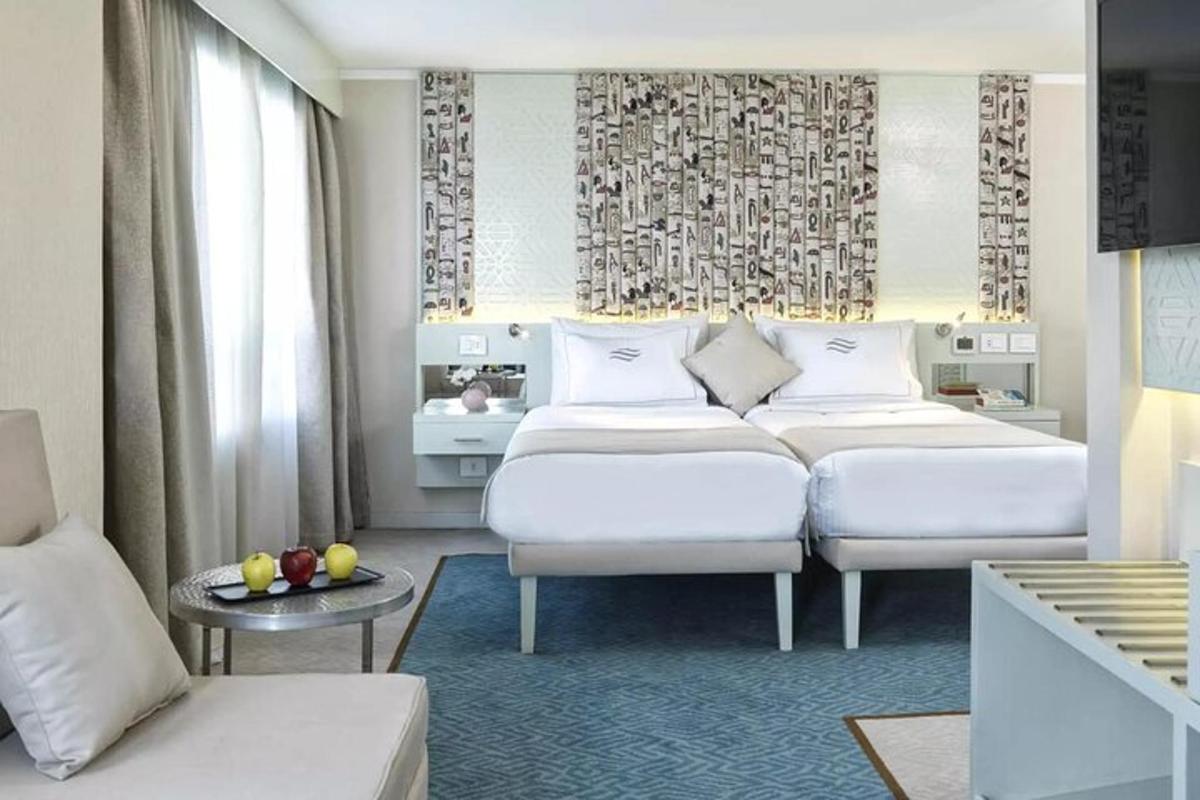 Un dormitorio con dos camas y un sofá y una mesa.