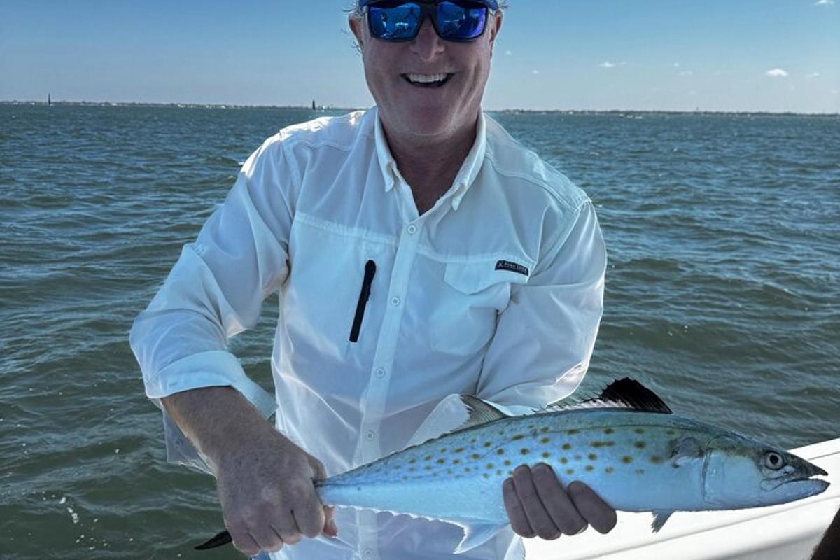 a man holding a fish in the water