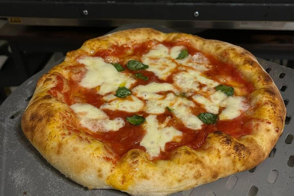 una pizza appoggiata su una teglia