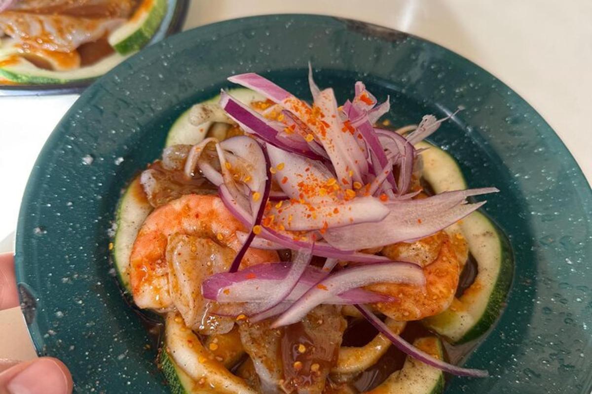 a green plate of food with shrimp and onions