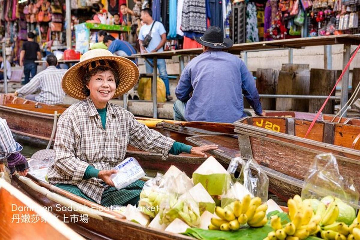 eine Frau mit Hut sitzt in einem Boot mit Bananen