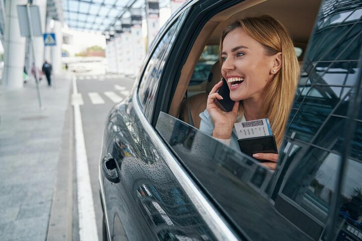 Una mujer sentada en un coche hablando por teléfono móvil.