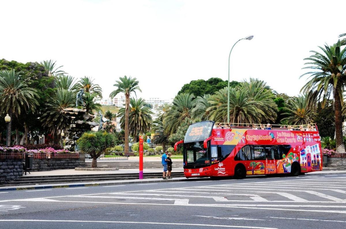 punane kahekordne buss sõidab mööda tänavat