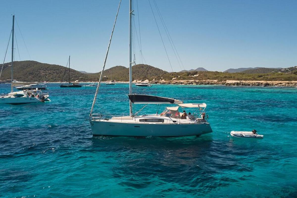 a sailboat in the water with other boats in the water