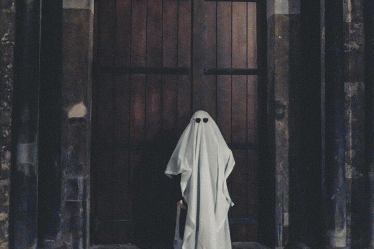 una persona in costume da fantasma in piedi davanti a una porta