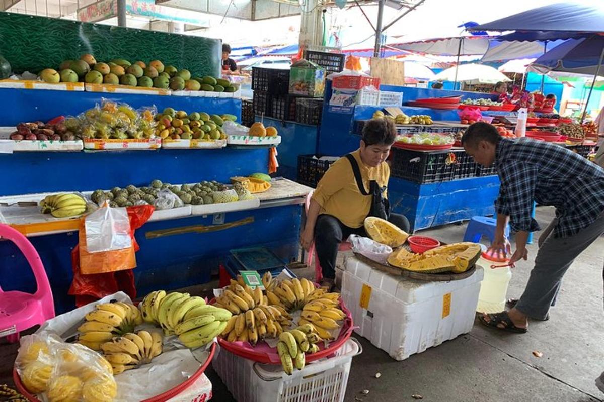 two people in a market with fruits and vegetables