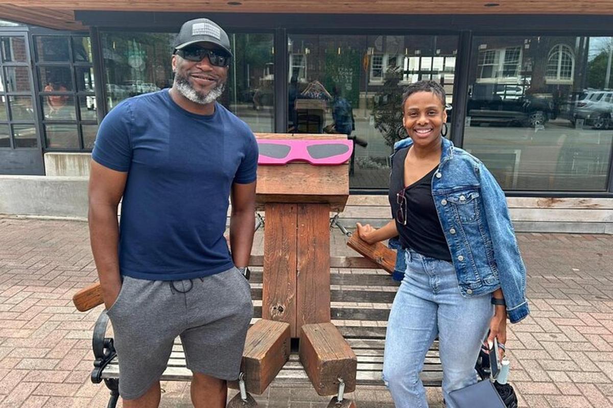 a man and a woman standing next to a wooden bench
