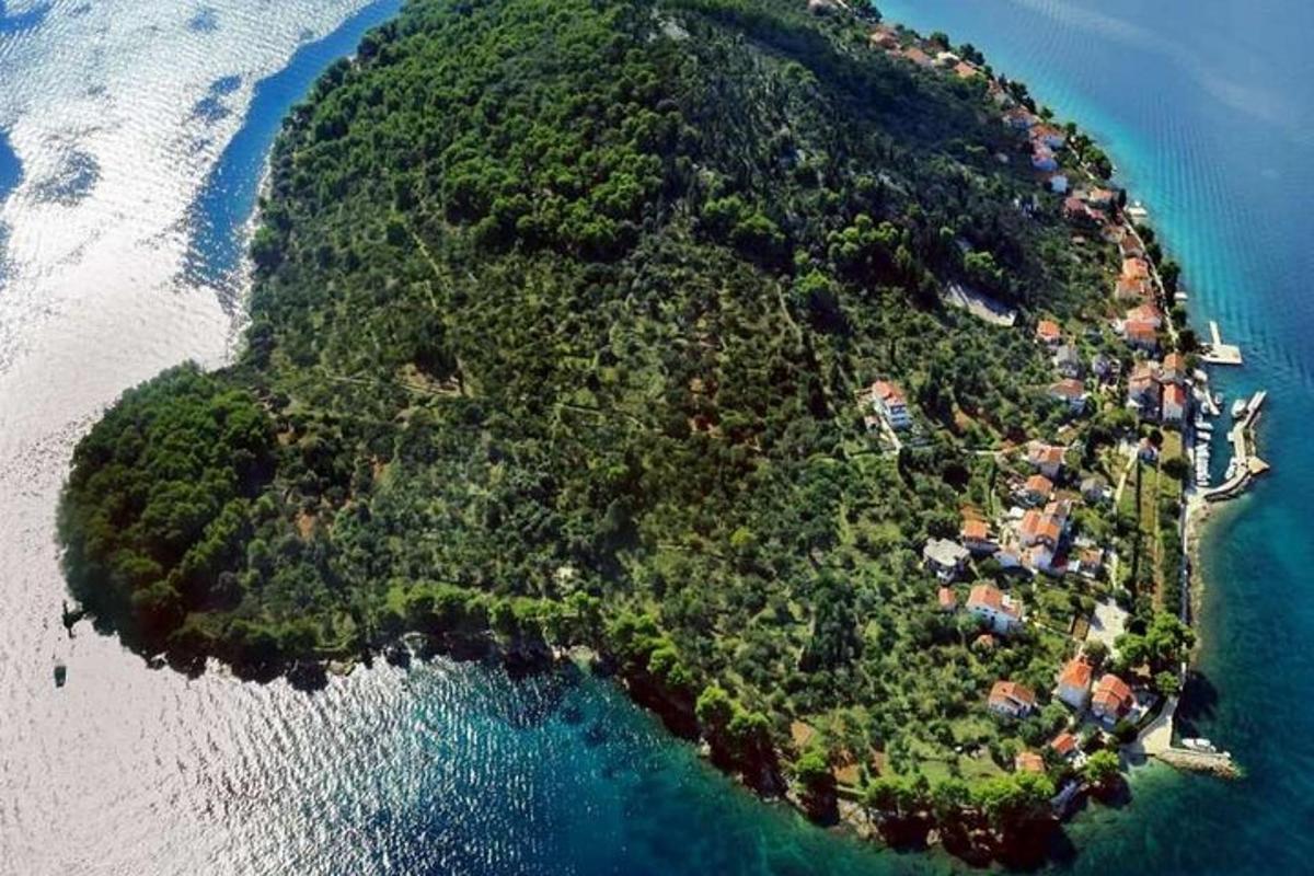 eine Insel im Ozean mit einer Gruppe von Häusern darauf