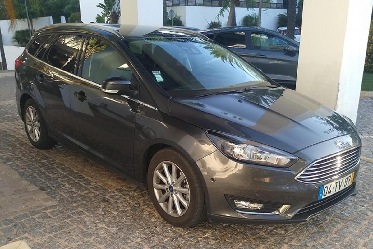 ein schwarzes Auto, das neben einem Gebäude geparkt ist
