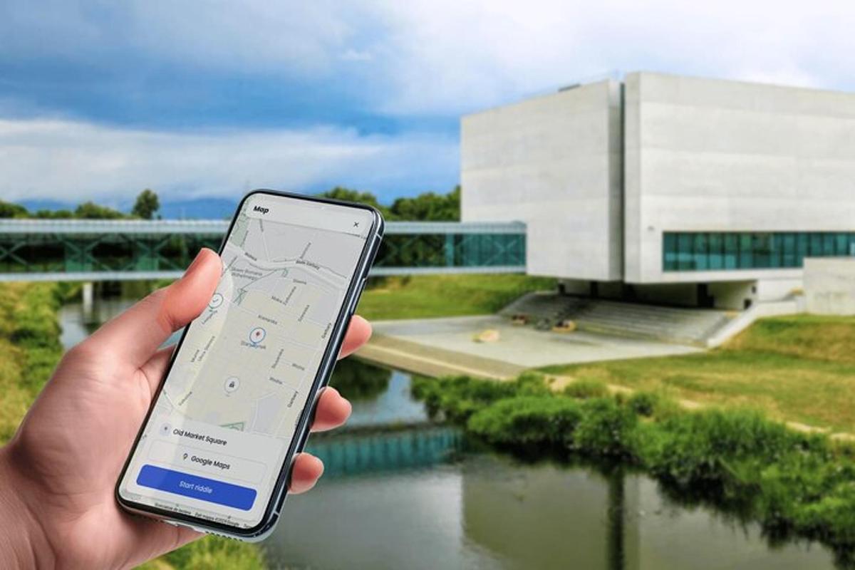 inimene, kes hoiab hoone ees mobiiltelefoni