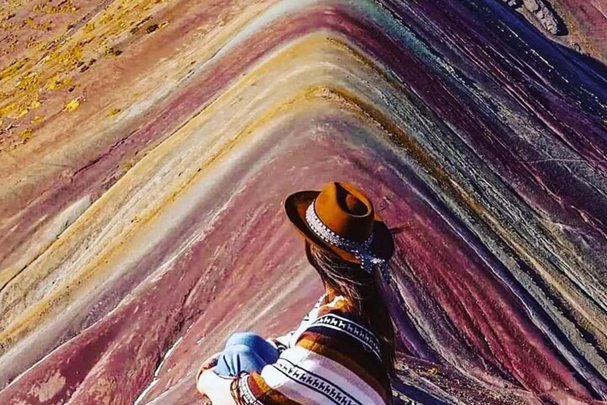 una persona con un cappello da cowboy che dipinge un muro