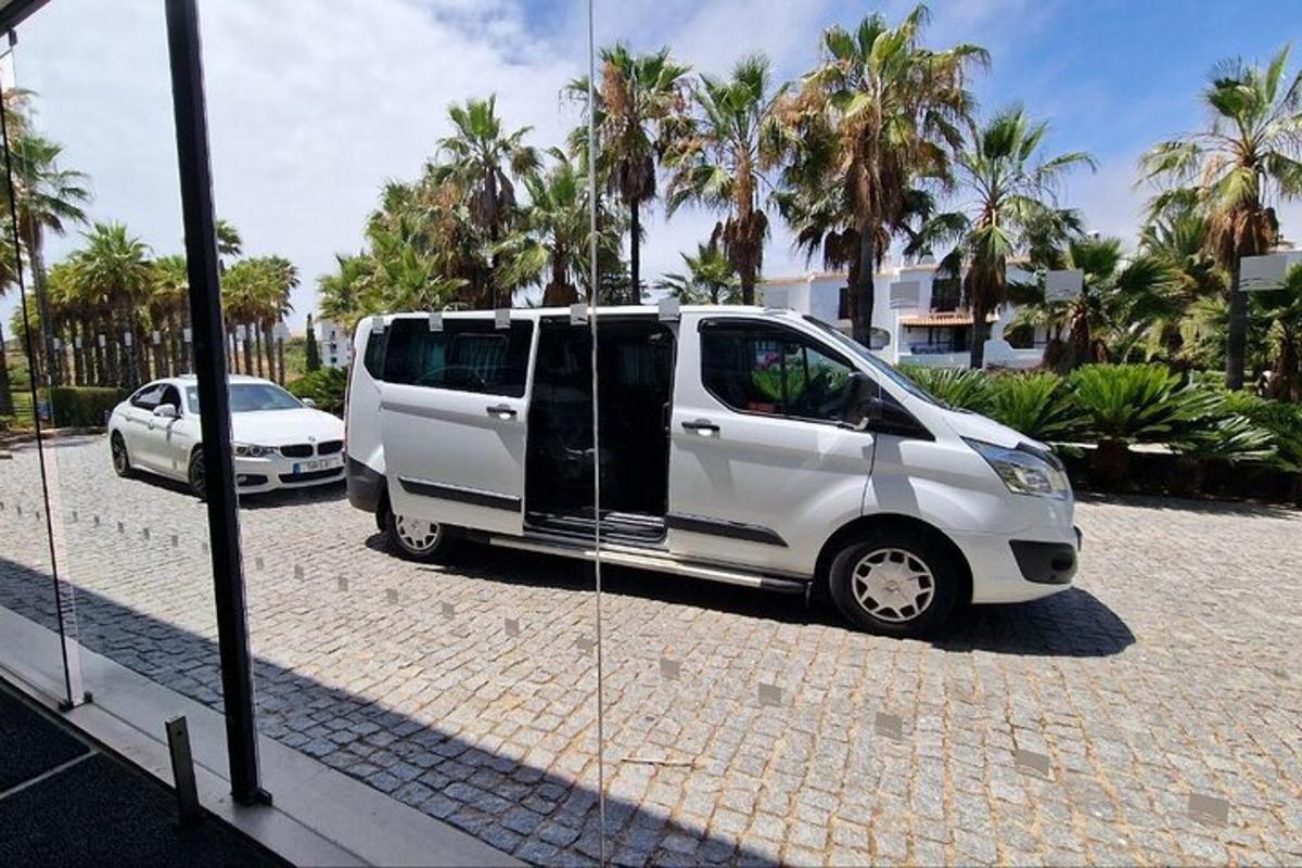 en hvit varebil står parkert på en parkeringsplass