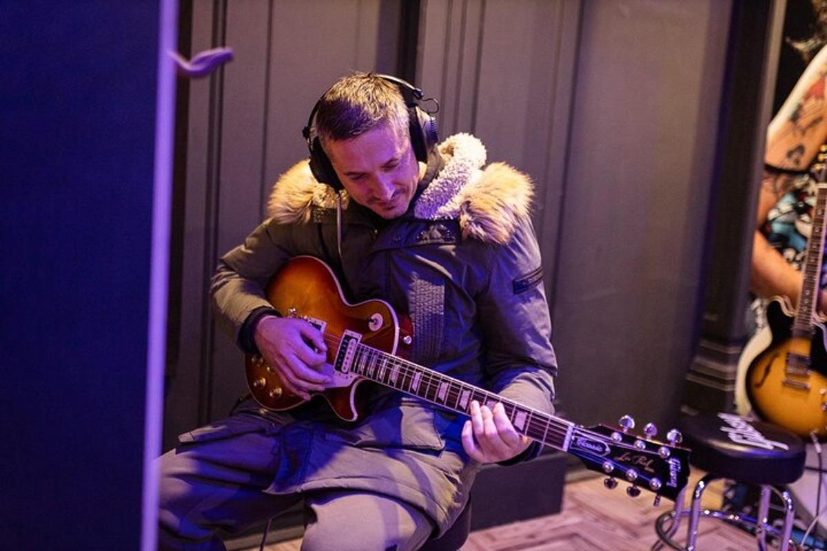 a man playing a guitar while wearing headphones