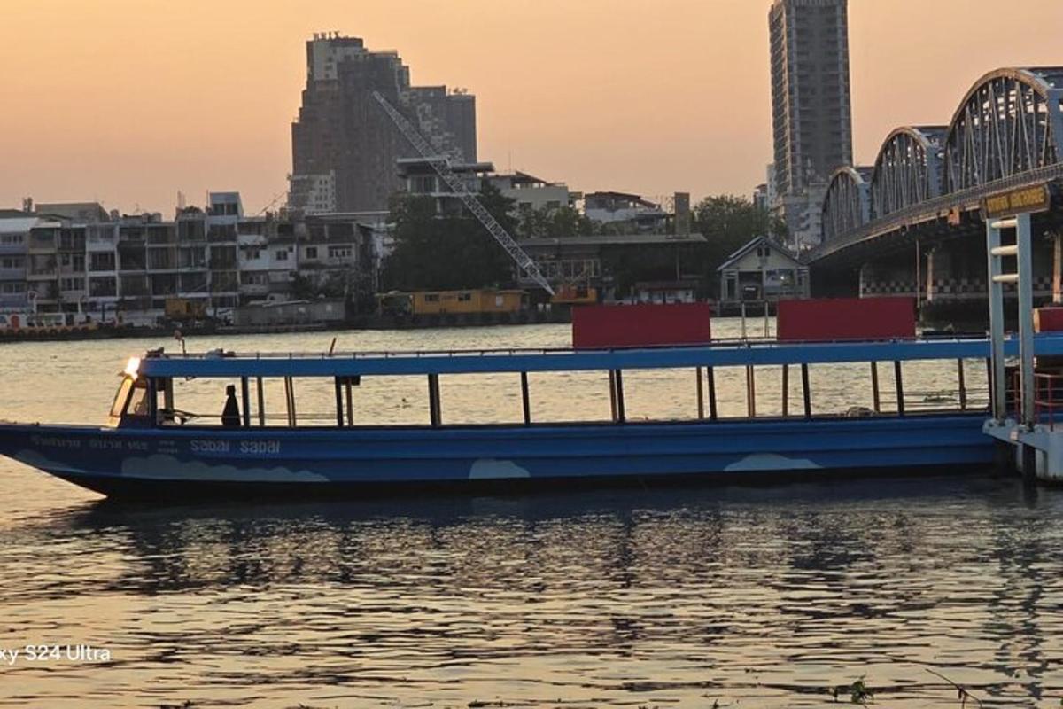 ein blaues Boot im Wasser neben einer Brücke