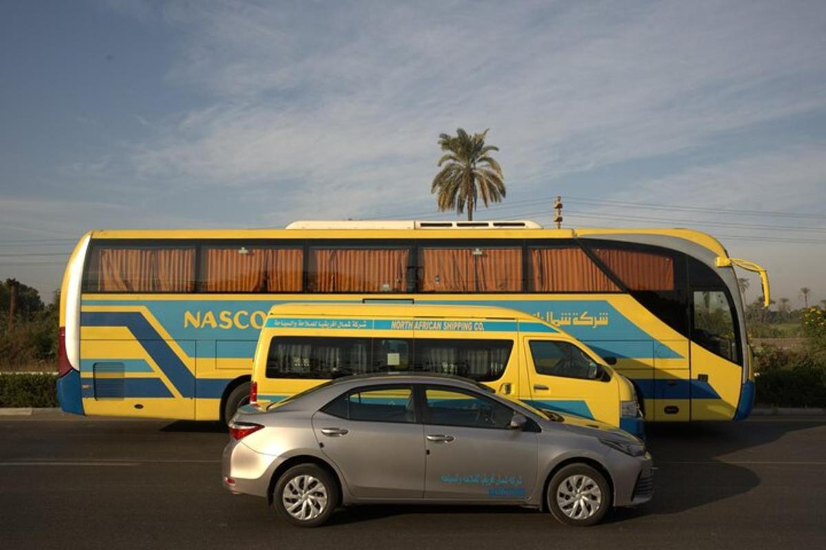 žlutý a modrý autobus a auto na parkovišti
