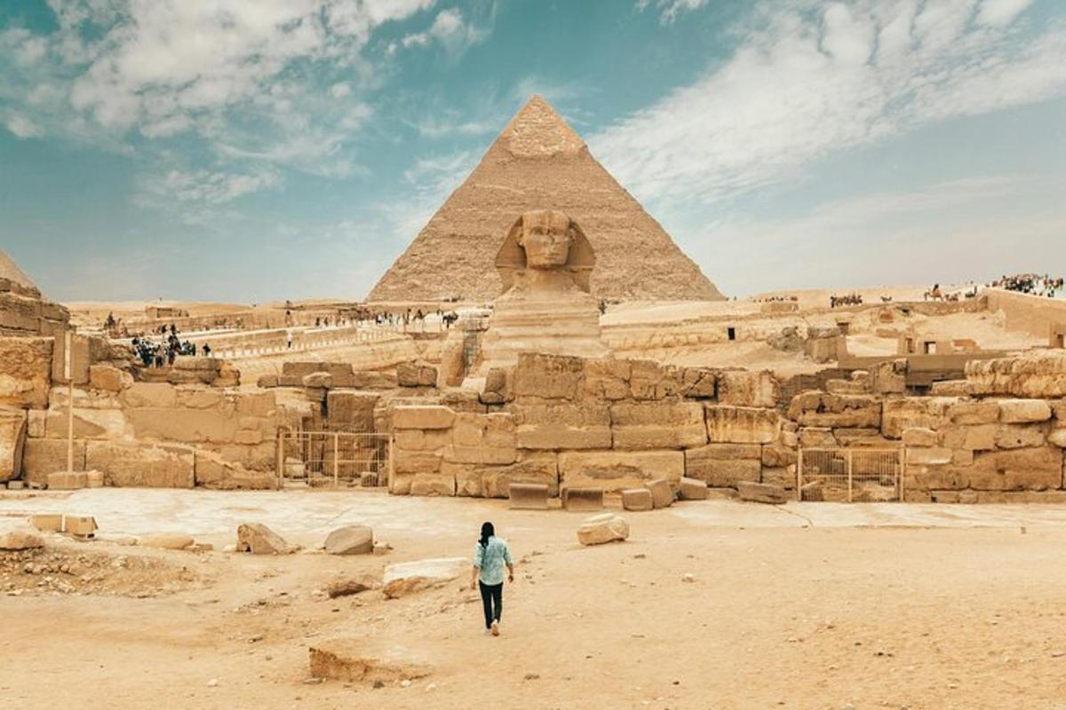 žena kráčející před pyramidami
