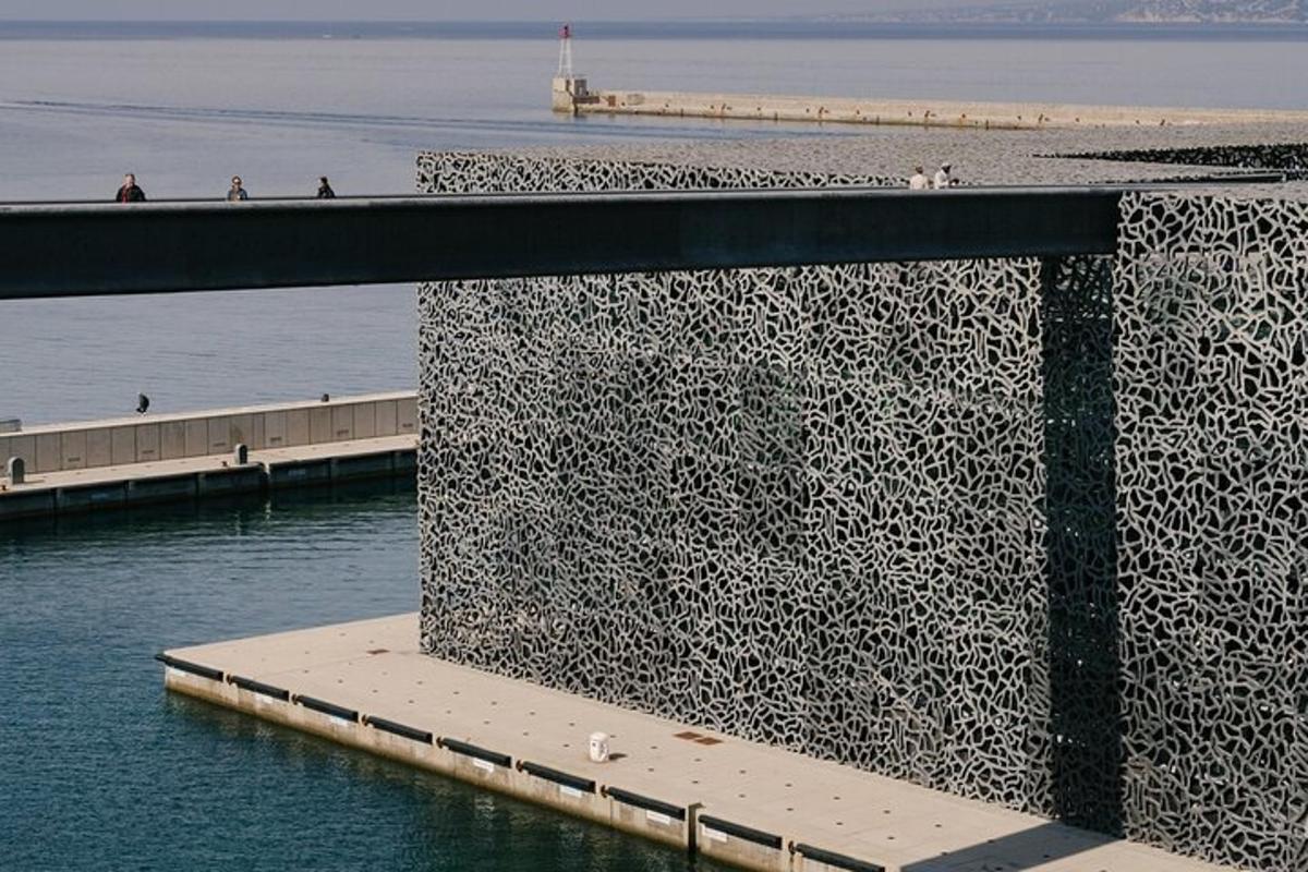 a large metal wall next to a body of water