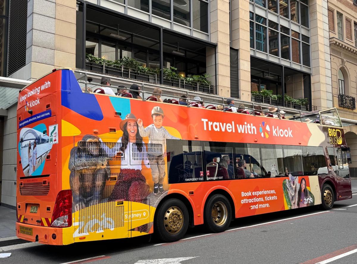 an orange double decker bus with an advertisement on it