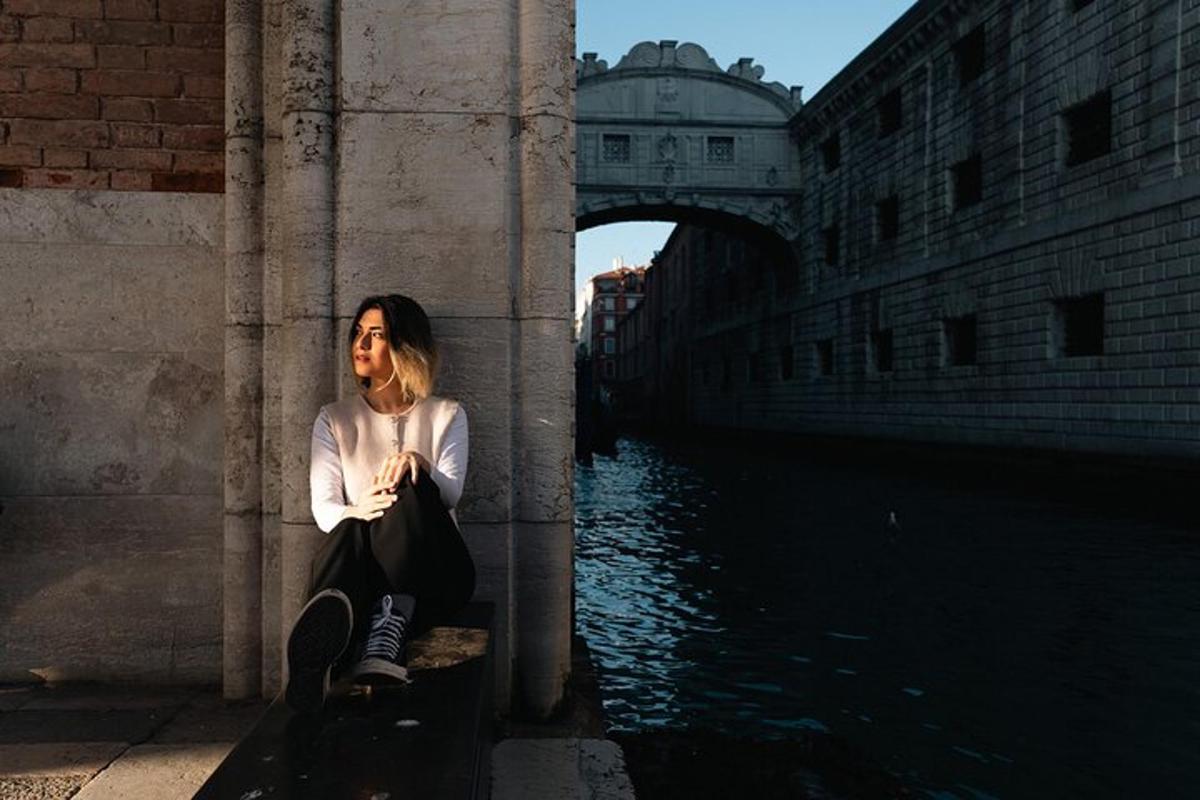 a woman sitting on a pillar next to a river
