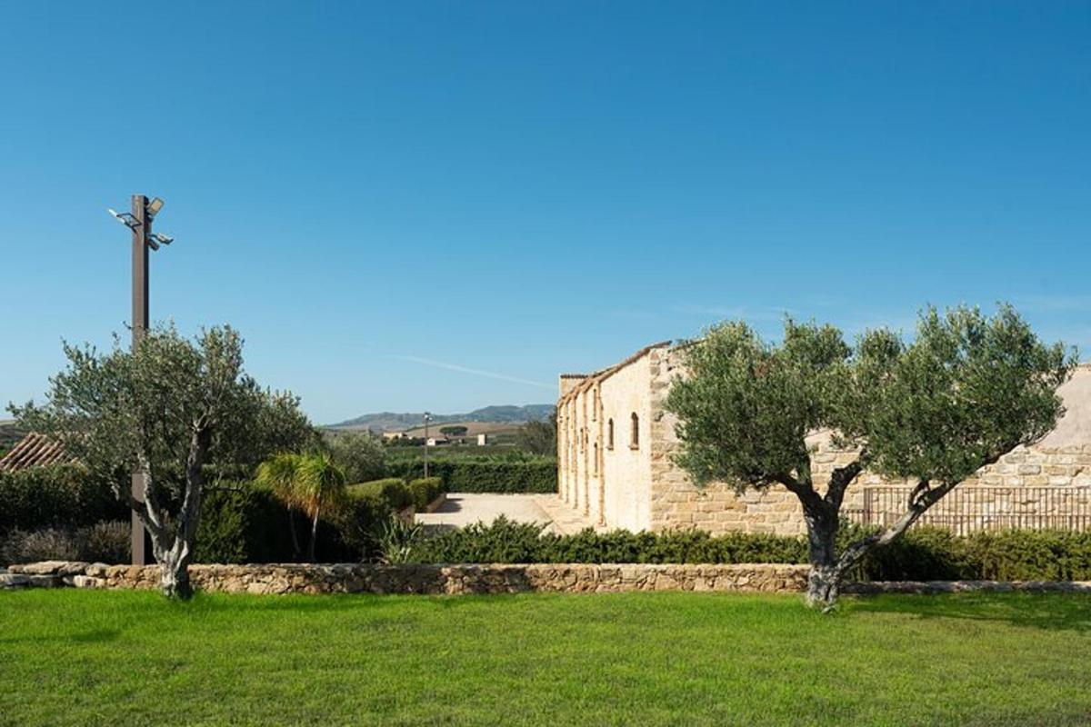 ein Gebäude auf einem Feld mit Bäumen und Gras