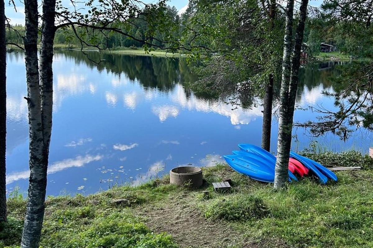 a blue canoe sitting on the shore of a lake