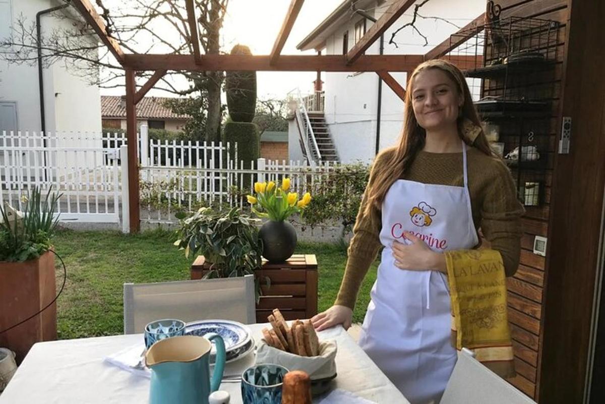 una ragazza con un grembiule in piedi accanto a un tavolo