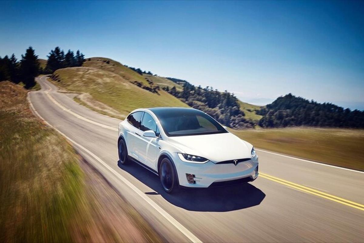 Hvítur Tesla-bíll ekur eftir götu