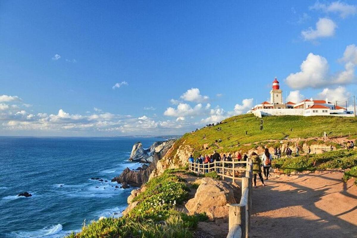 a lighthouse on top of a cliff next to the ocean