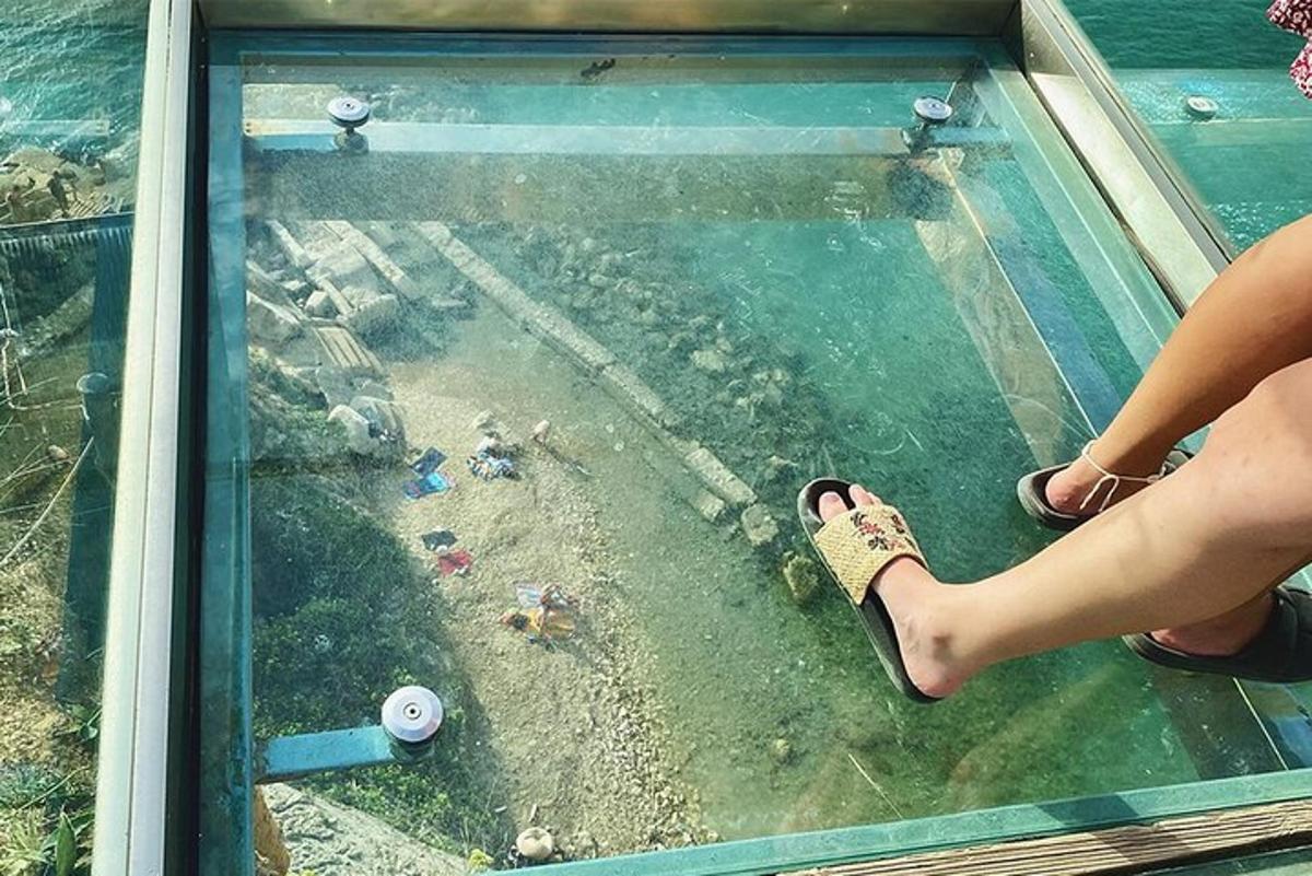 a person is standing on the glass floor of a glass tower