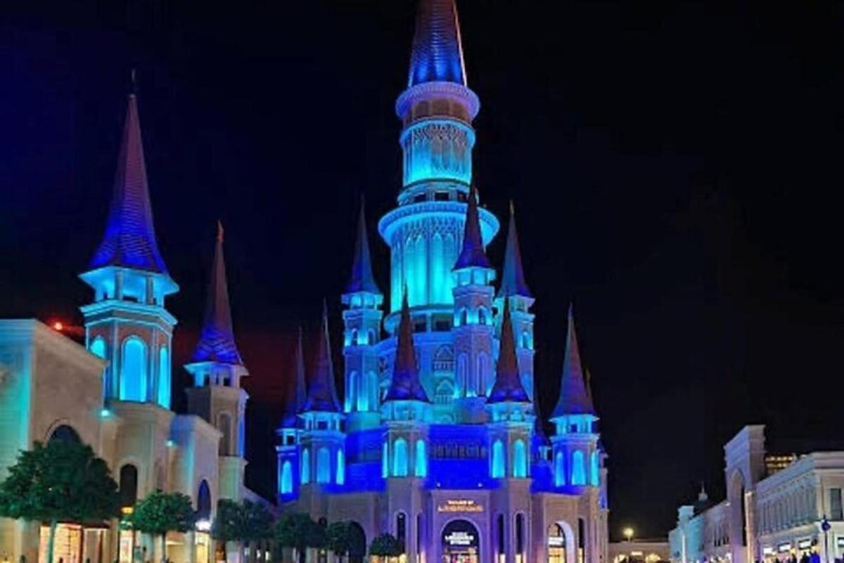 a disney castle lit up in blue at night