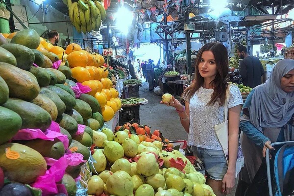 seorang wanita sedang berdiri di pasar buah-buahan