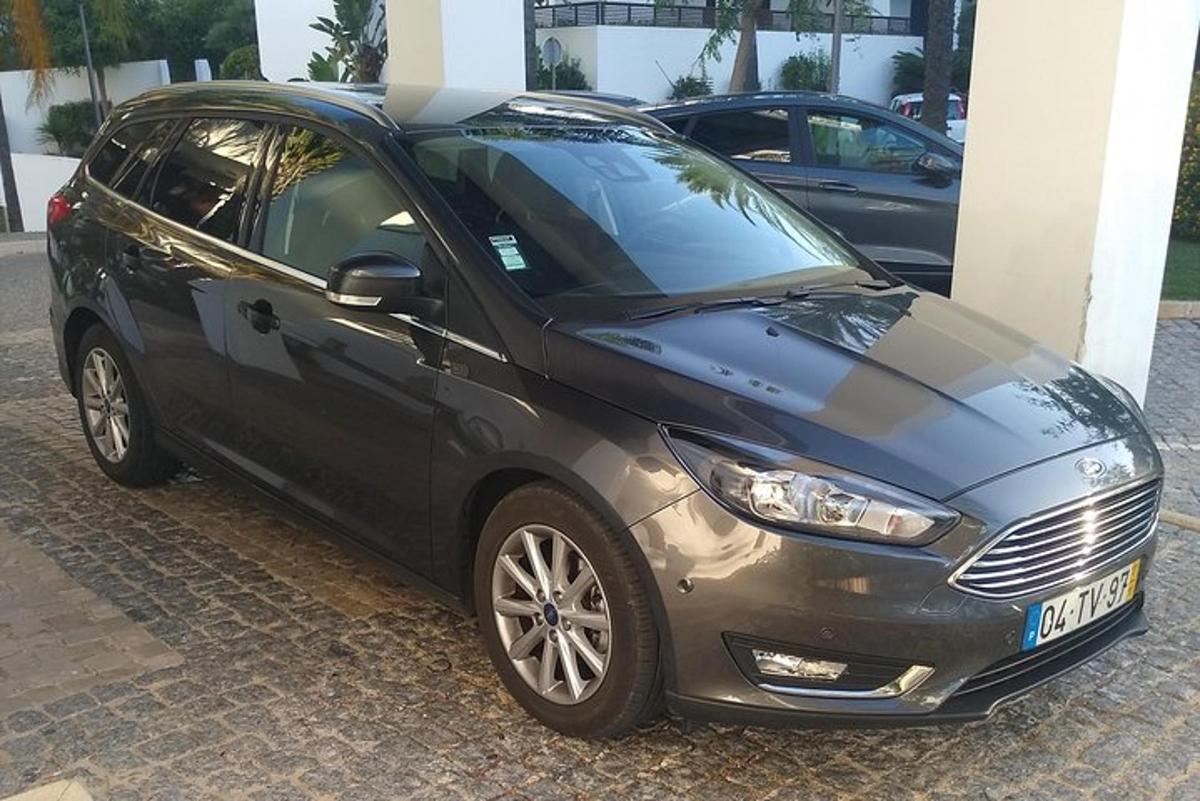 juodas automobilis, pastatytas priešais pastatą