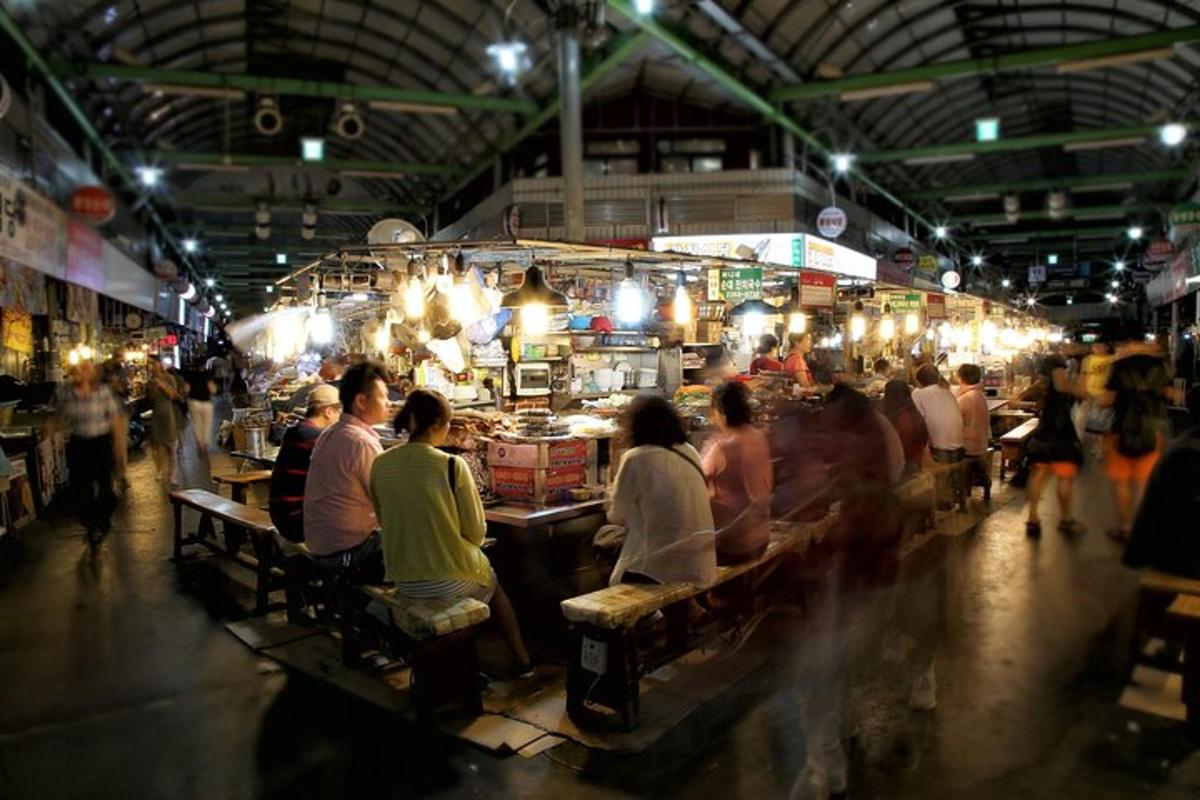 a group of people sitting at tables in a market