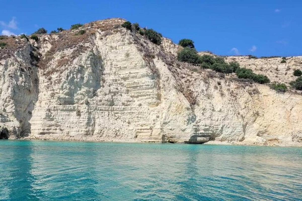 ένας βραχώδης γκρεμός με τα γαλάζια νερά μπροστά του