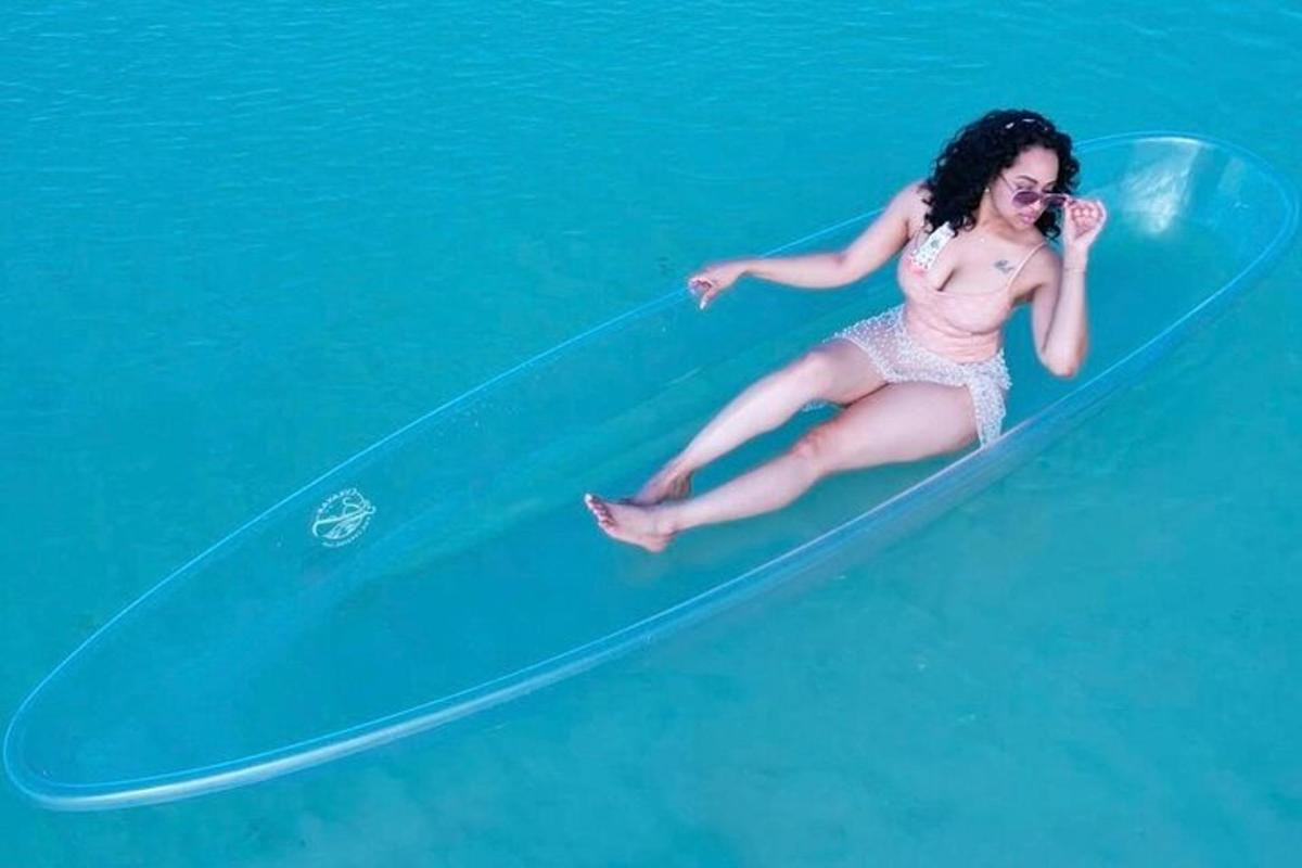 seorang wanita berbikini duduk di papan selancar di air