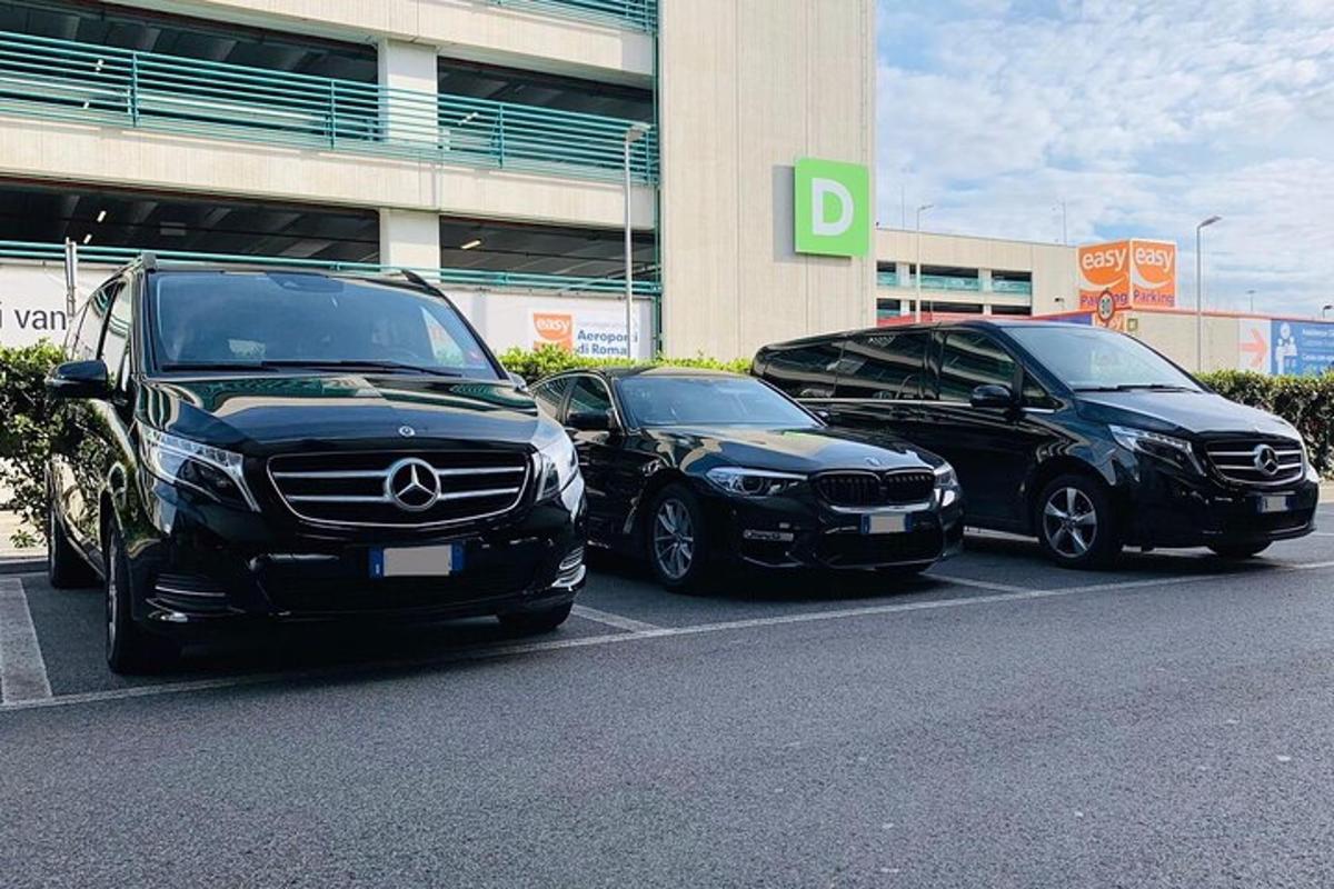 tatlong sasakyan ang nakaparada sa isang parking lot sa harap ng isang gusali