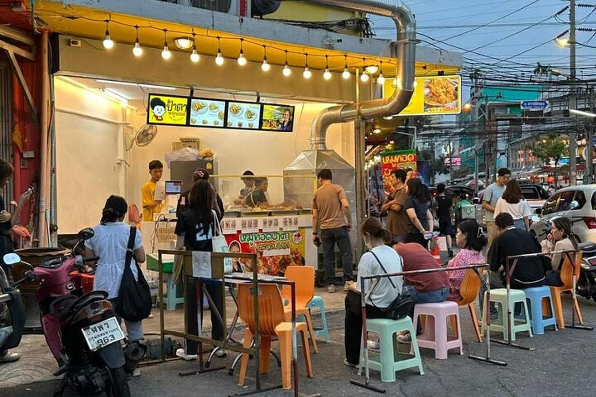 a group of people sitting outside of a food stand