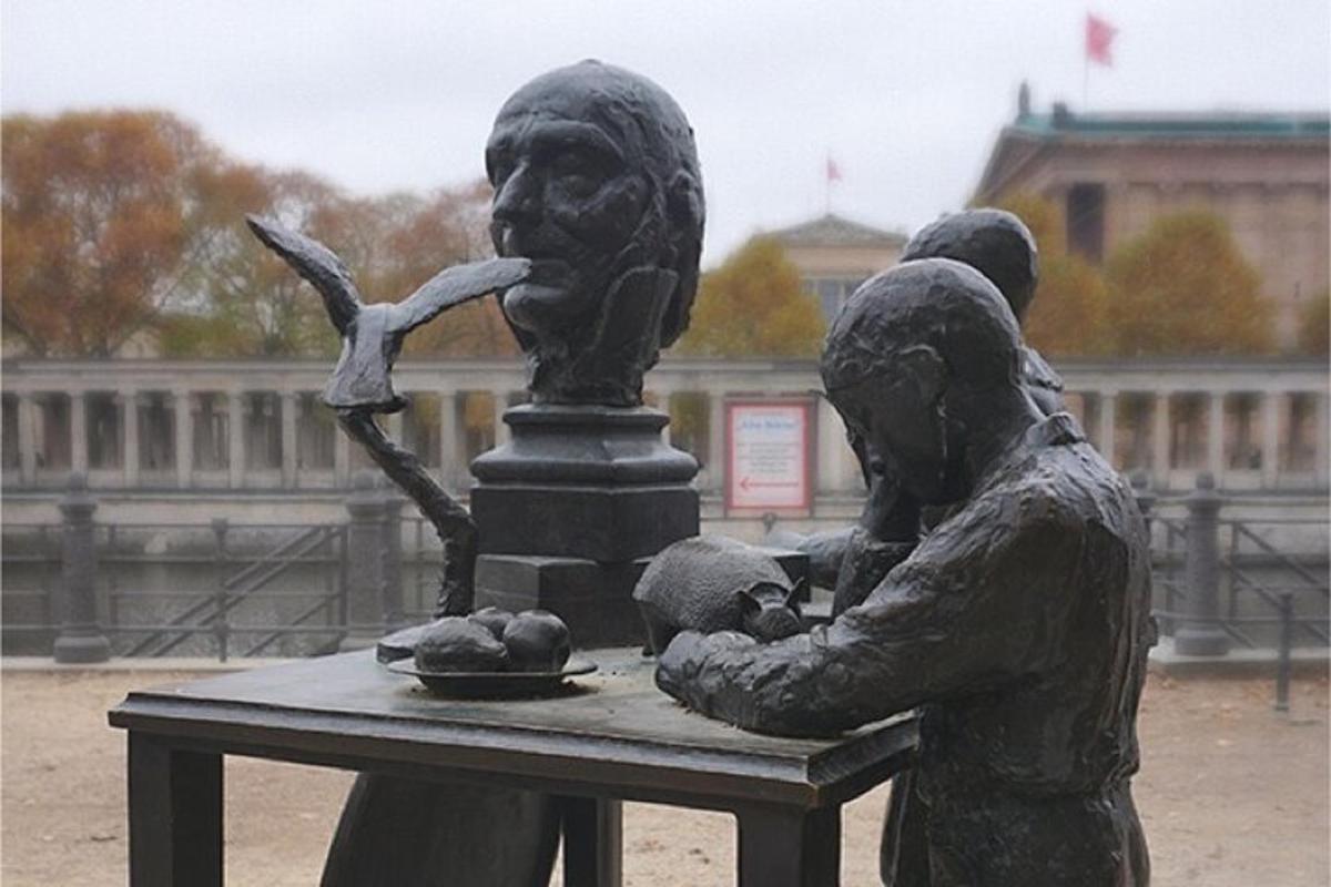 en statue av to personer som sitter ved et bord