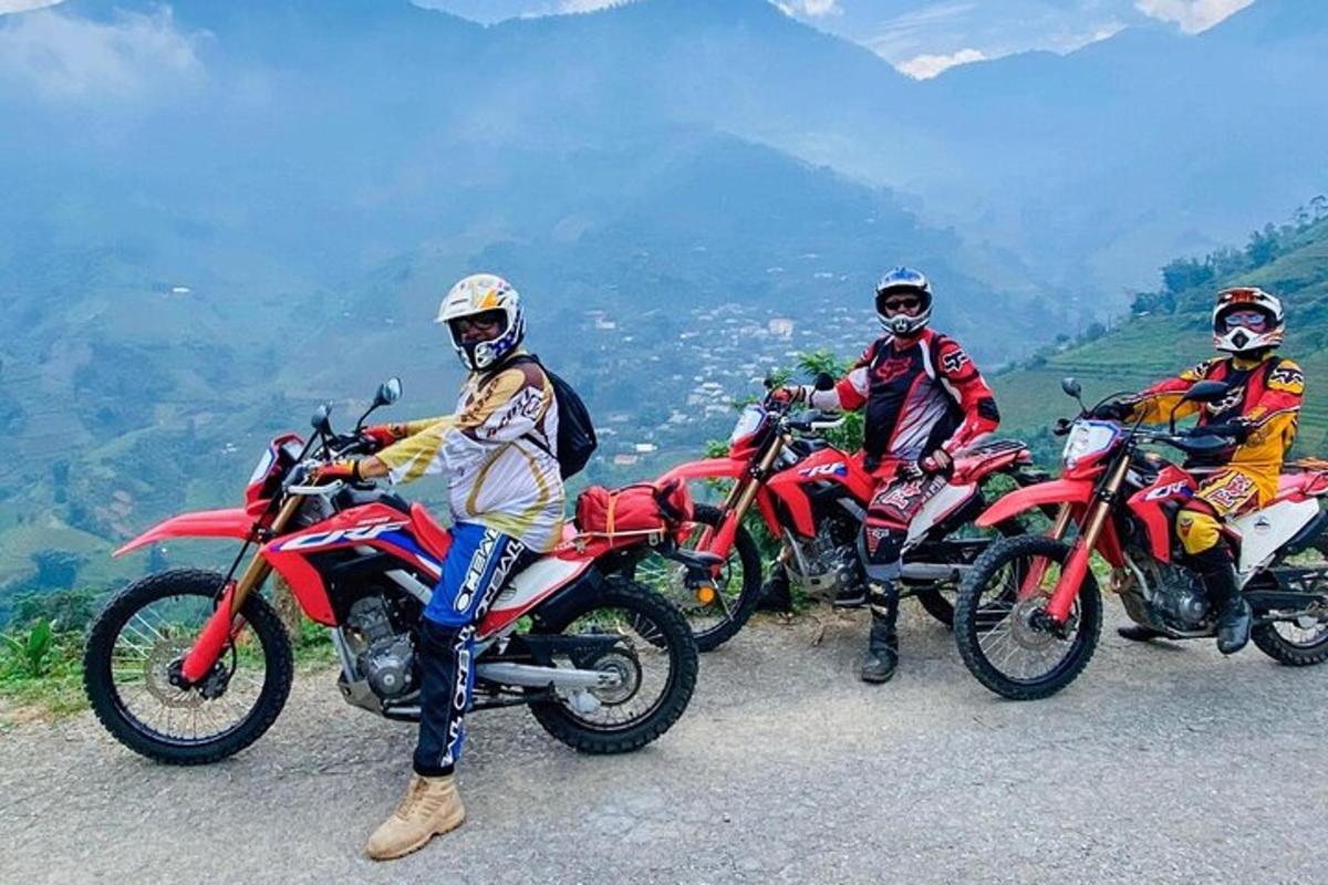 three people riding motorcycles on a mountain road