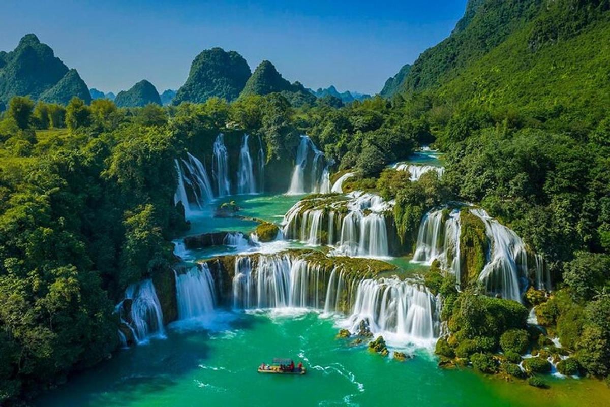 a waterfall with a boat in a river