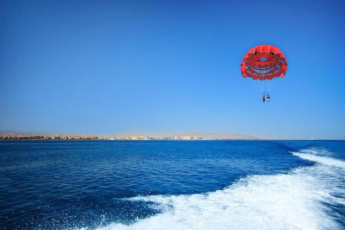 una cometa roja volando sobre un cuerpo de agua
