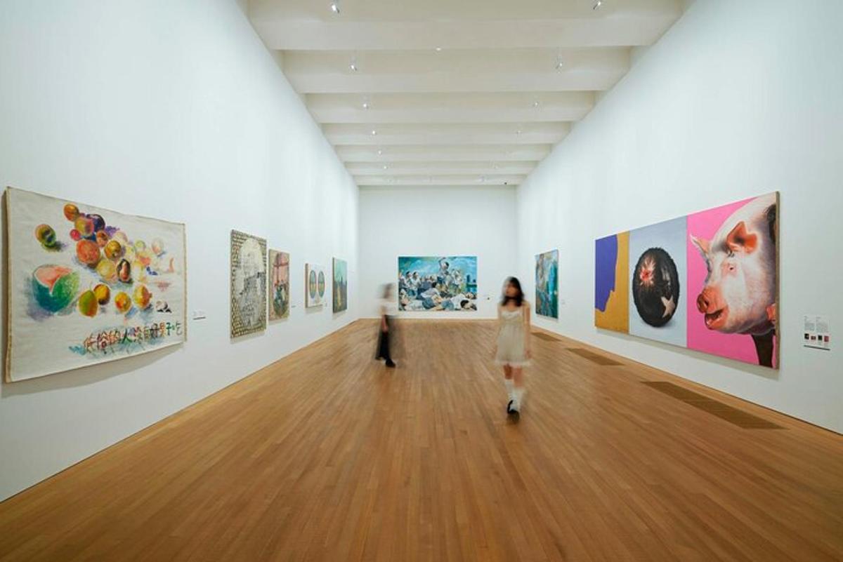 uma mulher caminhando por uma galeria de arte com pinturas