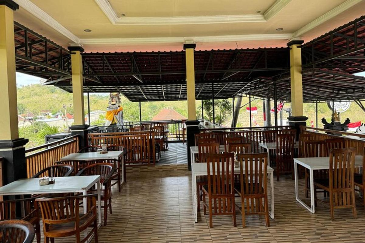 prázdná restaurace se stoly a židlemi a osobou v pozadí