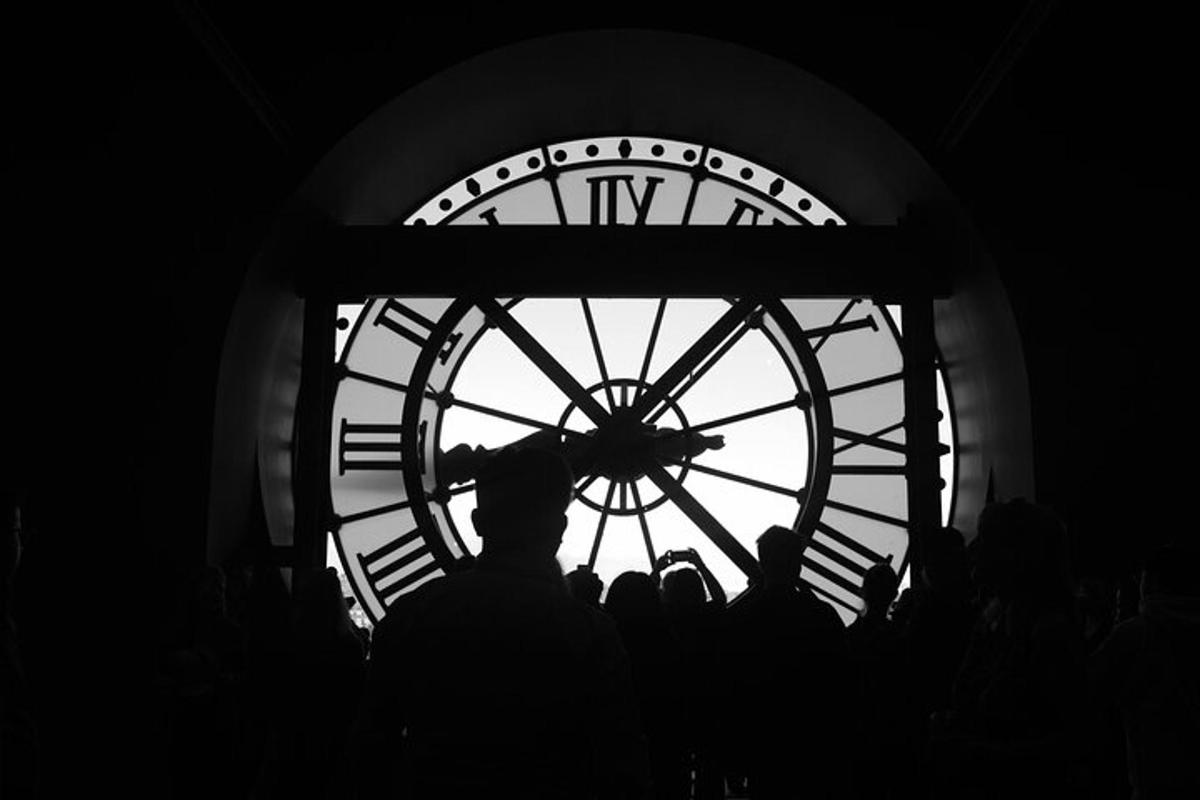 a group of people standing in front of a large clock