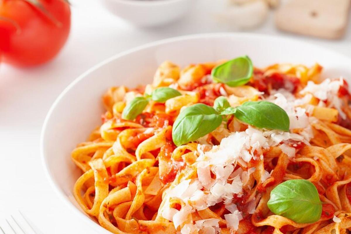 a bowl of pasta with cheese and basil on it