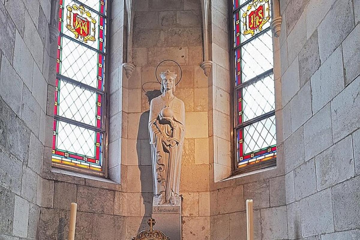 una estatua en el costado de un edificio con dos ventanas