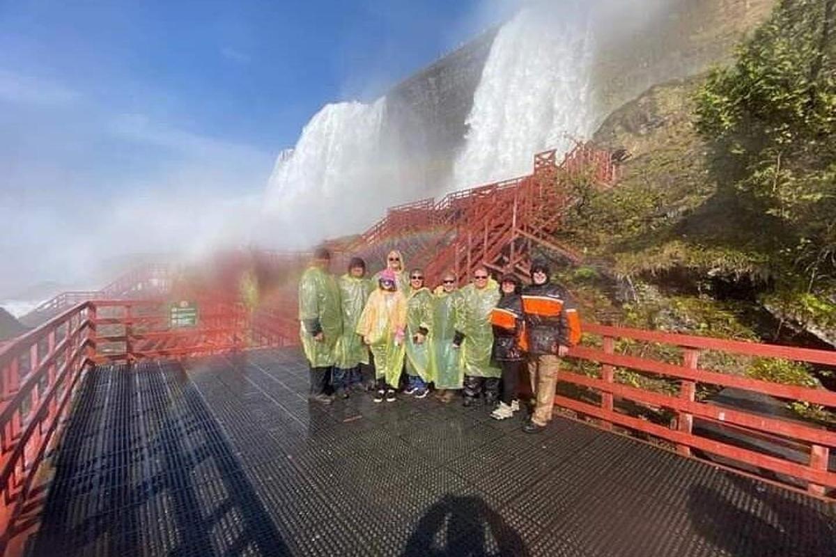 a group of people standing in front of a waterfall