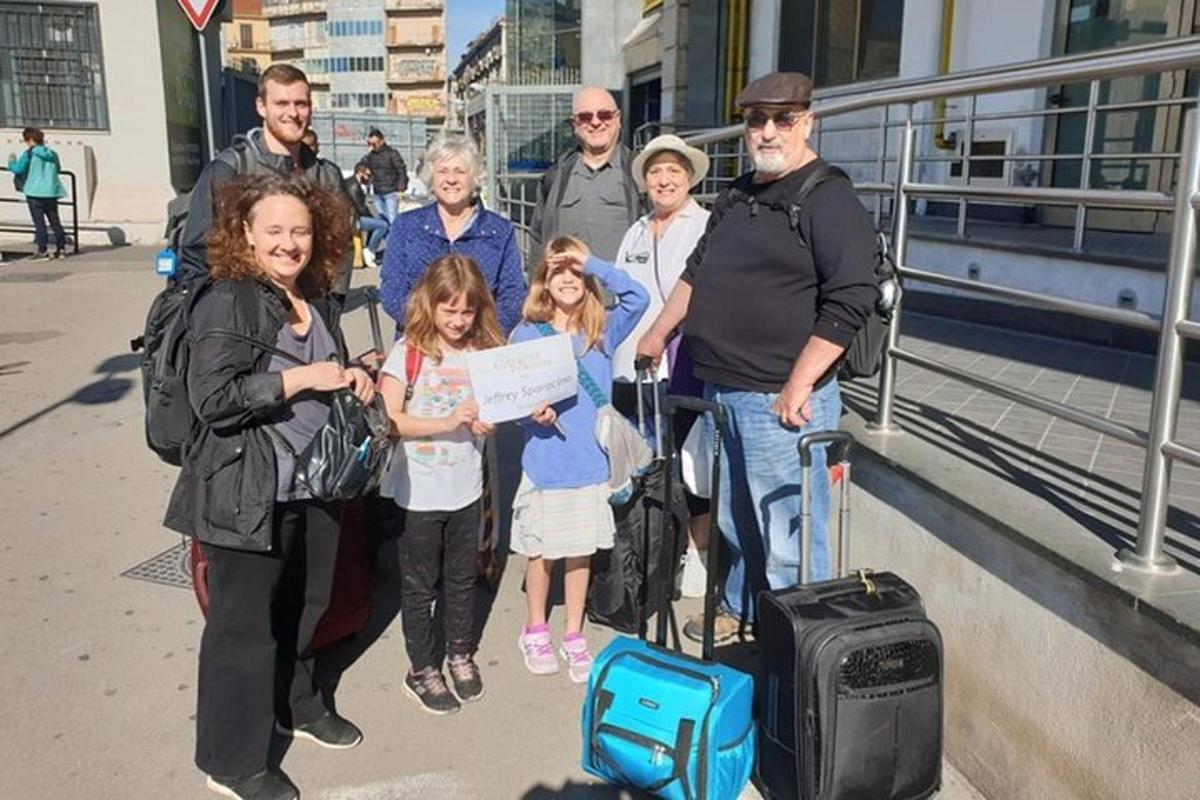 skupina lidí pózujících pro fotografii se zavazadly